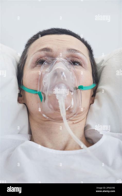 Close Up Of Mature Woman In Oxygen Mask Lying On Hospital Bed Stock