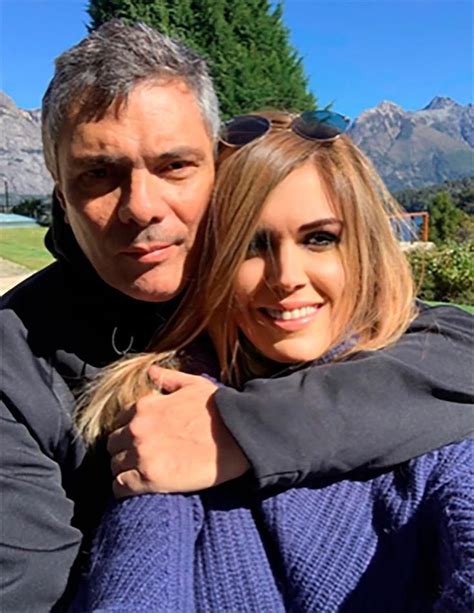 The Man And Woman Are Posing For A Photo In Front Of Some Mountains