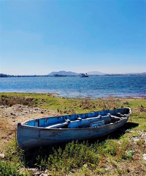 Um Barco Est Na Margem De Um Lago Uma Montanha Ao Fundo Foto