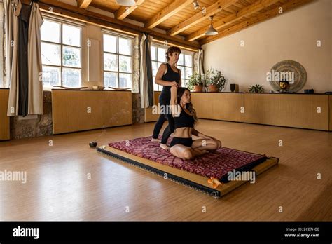 Female Yoga Instructor Helping Calm Woman Practicing Mindfulness In