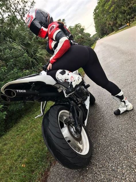 A Woman In Black And Red Riding On The Back Of A White Motorcycle Down