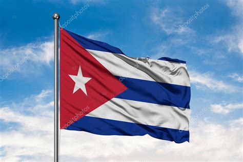 Bandera De Cuba Ondeando En El Viento Contra El Cielo Azul Nublado