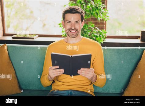 Photo Portrait Of Handsome Mature Man Reading Book Sit Couch Dressed