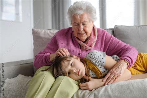 Sad Girl Lying Head On Gradmother Knees And Crying Grandma Soothing