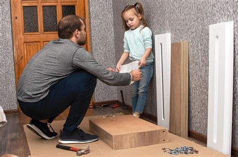 Un hombre ensambla muebles en casa con sus propias manos y su pequeña