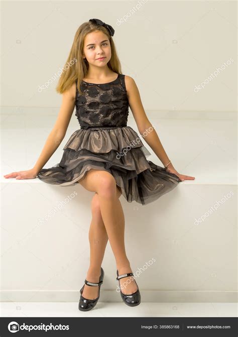 Cute little girl is sitting in the studio on the white stairs. style ...