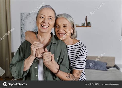 Mature Lesbian Couple Embraces Modern Apartment Both Smiling Happily Look Stock Photo