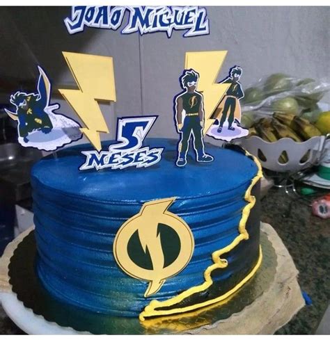 A Blue And Yellow Birthday Cake With The Flash Logo On Top Surrounded