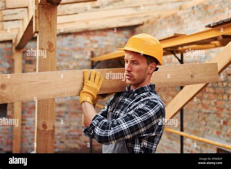 Transporting Wooden Boards Construction Worker In Uniform And Safety