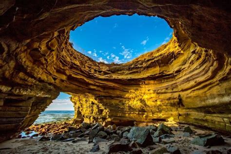 the inside of a cave with rocks and water in it, looking out into the ...