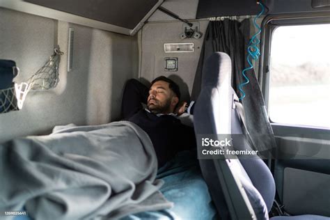 Conductor De Camión Durmiendo En La Cama De La Cabina En La Parada Del