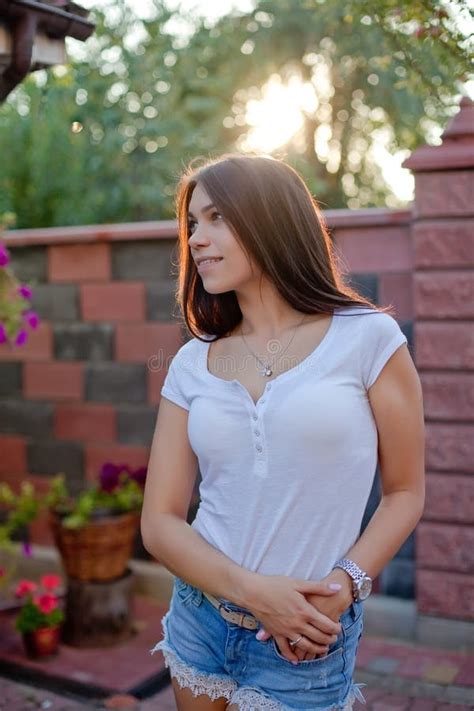 Smiling Young Brunette Woman Posing In Yard Of Her Residence Stock