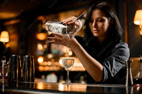 Professional Bartender Girl Pouring A Trasparent Alcoholic Drink From