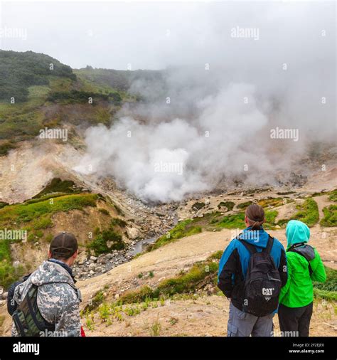 Group Of Travelers And Tourists Observes Mysterious Volcanic Landscape Hot Spring Eruption