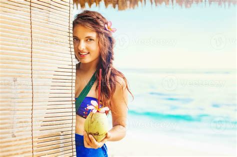 A Woman In A Bikini Holding A Coconut Stock Photo At Vecteezy