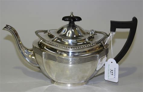 A George V Silver Teapot Of Oval Form With Gadrooned Rim Above A