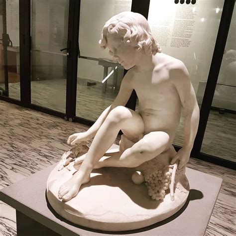 A Statue Of A Man Sitting On Top Of A Table Next To A Glass Case