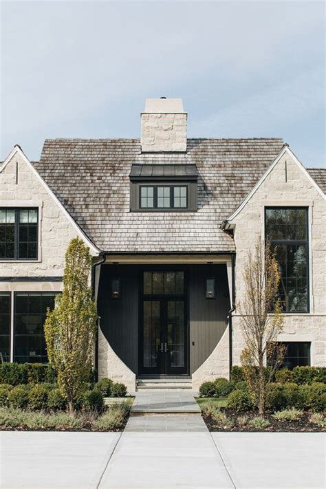 The Front Entrance To A Large Home With Stone And Shingles On It S Roof