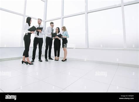 Employees Discuss Business Documents Standing In The Office Lobby Stock