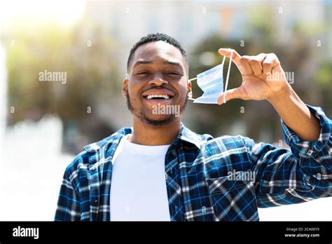 Portrait Of Happy Man Taking Off Mask In The City Stock Photo Alamy