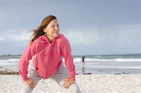 Mujer Madura Atractiva Que Ejercita En La Playa Foto De Archivo