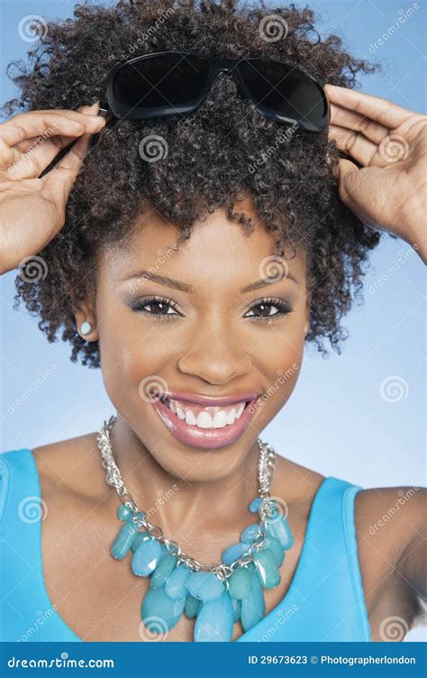 Portrait Of African American Woman Adjusting Sunglasses Over Colored