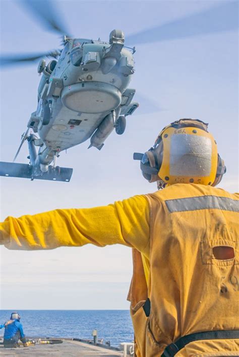 Crew Signals To An MH 60R Sea Hawk Helicopter Attached To The