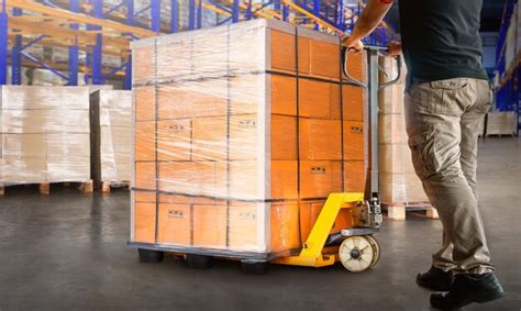 Premium Photo Workers Unloading Package Boxes On Pallets In Warehouse