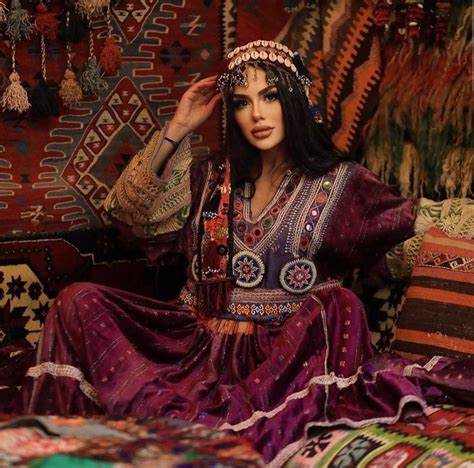 A Woman Sitting On Top Of A Bed In A Room Filled With Rugs And Pillows