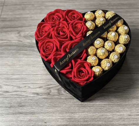 A Heart Shaped Box With Roses And Chocolates In The Shape Of A Heart On