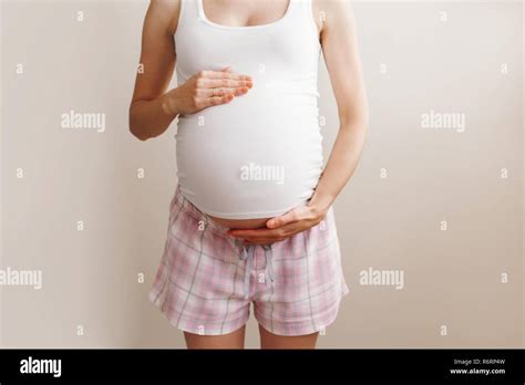 Closeup Body Of White Caucasian Blonde Pregnant Woman In Home Clothes