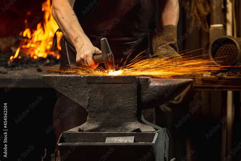 Close Up Working Powerful Hands Of Male Blacksmith Forge An Iron