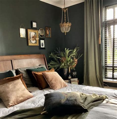 A Bedroom With Green Walls And Pillows On The Bed Along With A Chandelier