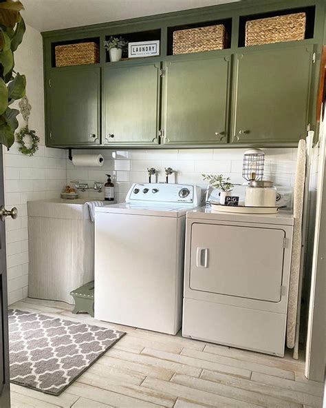 Olive Green Cabinets Hang On A White Shiplap Laundry Room Wall The