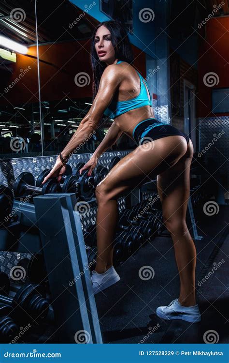 Fitness Brunette Woman Is Posing In The Dark Gym Near The Dumbbells Row Stock Image Image Of