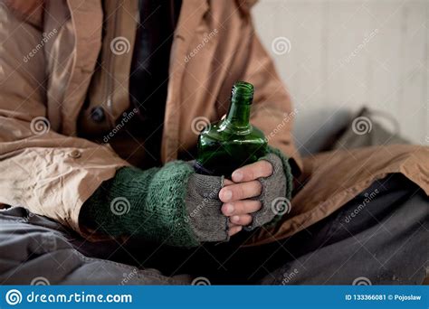 A Midsection View Of Homeless Beggar Man Sitting Outdoors Holding