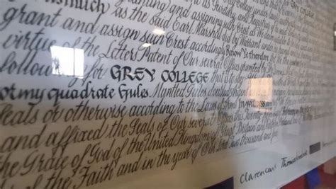 there is a wall with writing on it in the building that houses grey ...