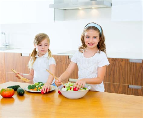 Hermanas Hermosas Del Cocinero En La Cocina Que Prepara La Ensalada