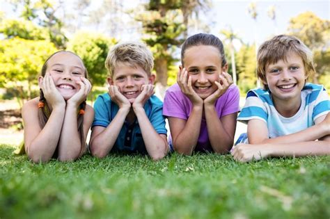 Premium Photo | Happy children lying on grass