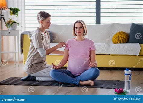 Pregnant Woman Doing Yoga Exercise With Instructor At Home Stock Image