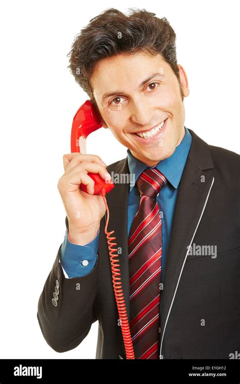 Smiling Business Man Making Phone Call With A Red Telephone Stock Photo