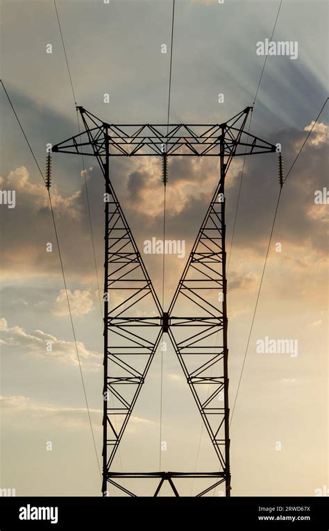 High Tension Tower At Sunset With A Cloudy Sky In The Background Stock