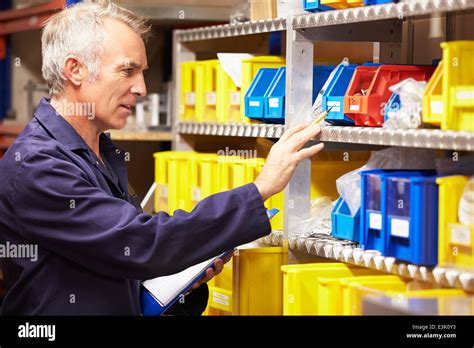 Worker Checking Stock Levels In Store Room Stock Photo Alamy
