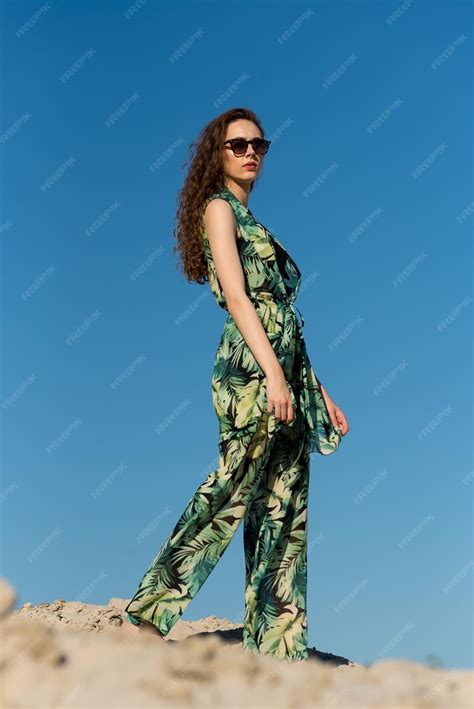 Premium Photo A Woman In A Green Jumpsuit Walks On A Rock