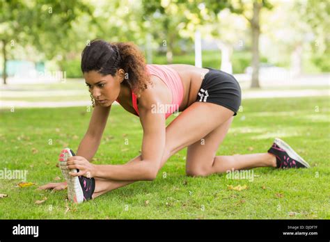 Full Length Of A Toned Woman Doing Stretching Exercise In Park Stock