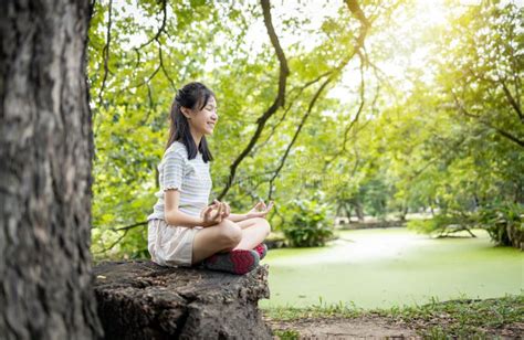 Happiness Woman Meditating In Yoga Pose Or Lotus Position Under The