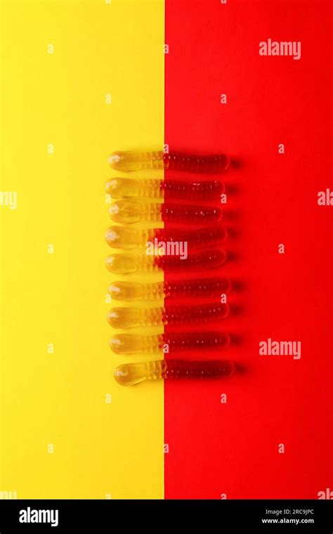 Gummi Worms Isolated On Plain Red And Yellow Background Stock Photo Alamy