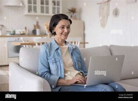 Happy Positive Mature Lady Using Computer For Internet Communication