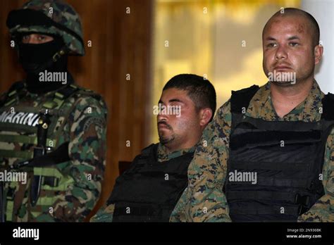 Two Men Wearing Bulletproof Vests And Camouflage Military Fatigues And