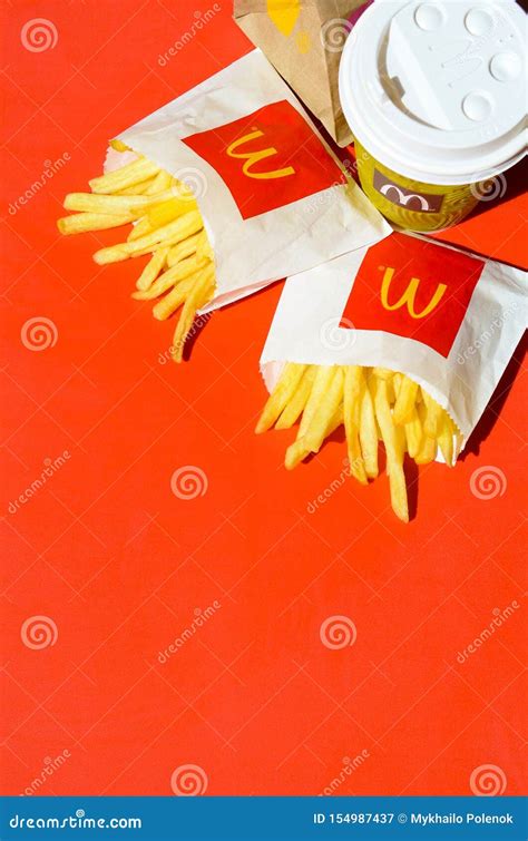 Mcdonald`s French Fries In Small Paperbag And Coffee Cup On Bright Red